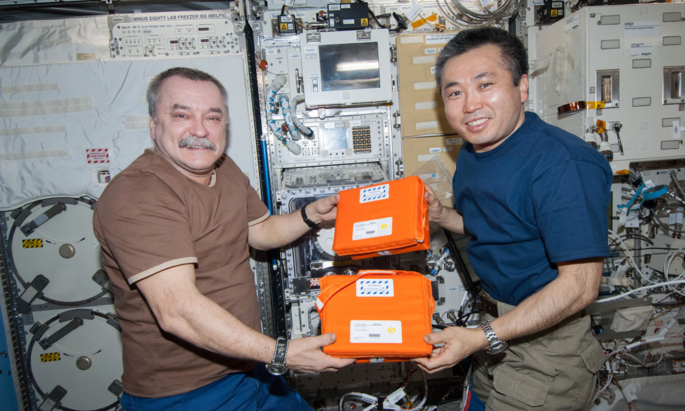 Astronauts holding containers (JAXA/NASA)